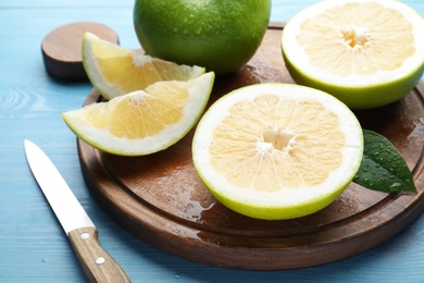 Photo of Cut fresh juicy sweeties on blue table