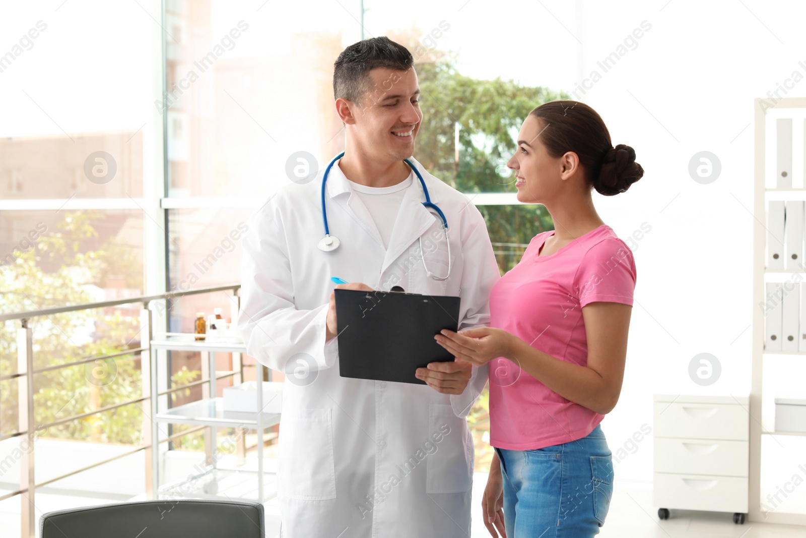 Photo of Young doctor consulting patient in modern hospital