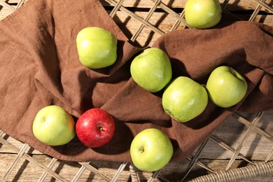 Photo of Fresh colorful apples on rattan grid, flat lay