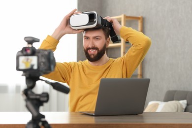 Technology blogger recording video review about virtual reality headset at home