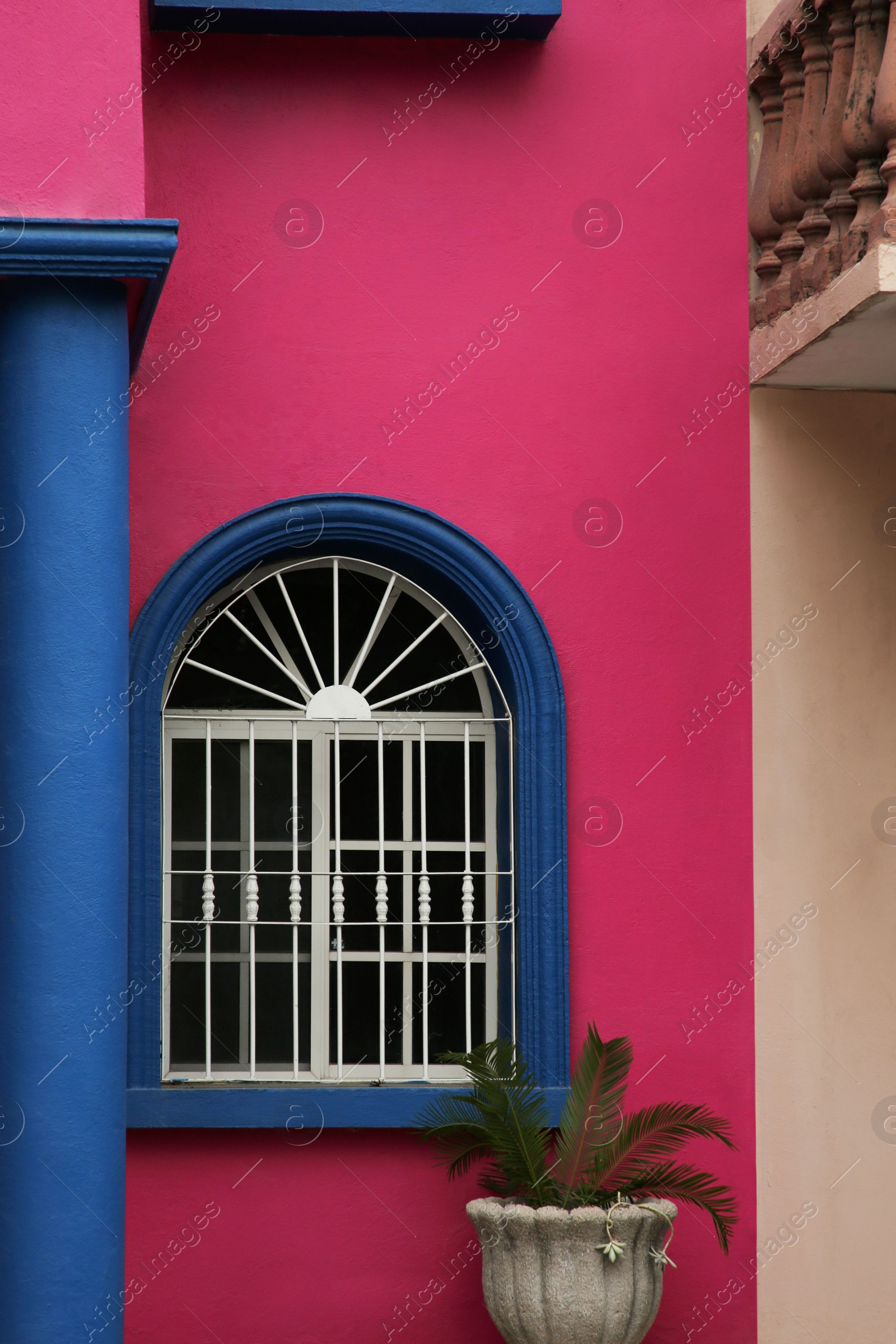 Photo of Colorful building with beautiful window and steel grilles outdoors