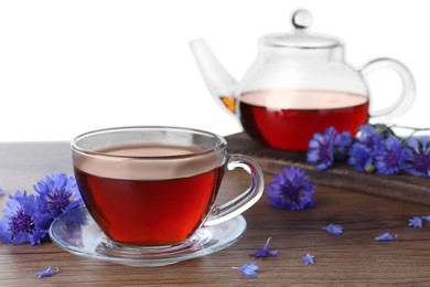 Photo of Cornflower tea and fresh flowers on wooden table