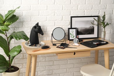 Photo of Dressing table with mirror, makeup products and accessories in room