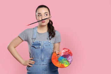 Photo of Woman with painting tools on pink background, space for text. Young artist