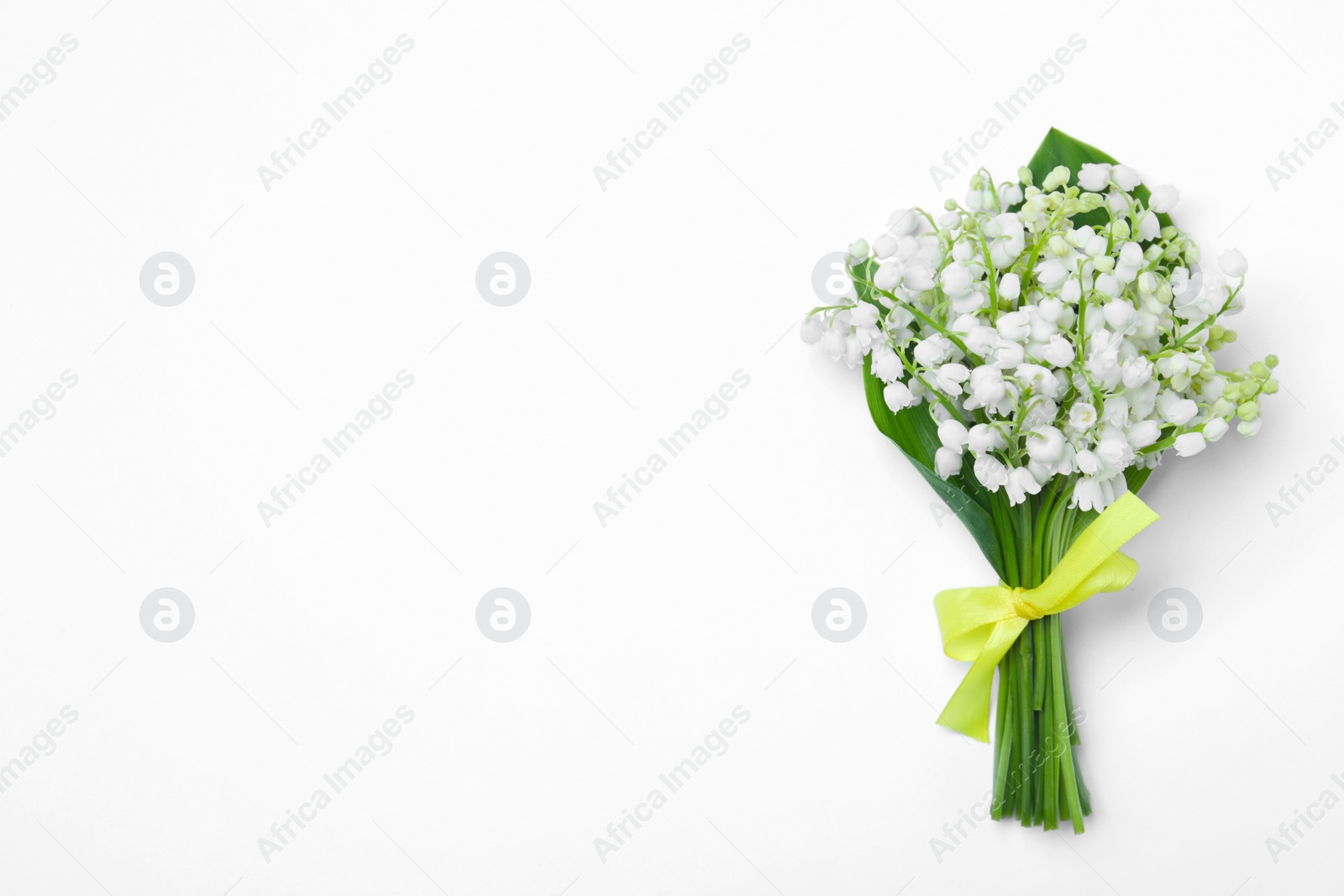 Photo of Beautiful lily of the valley flowers on white background, top view. Space for text