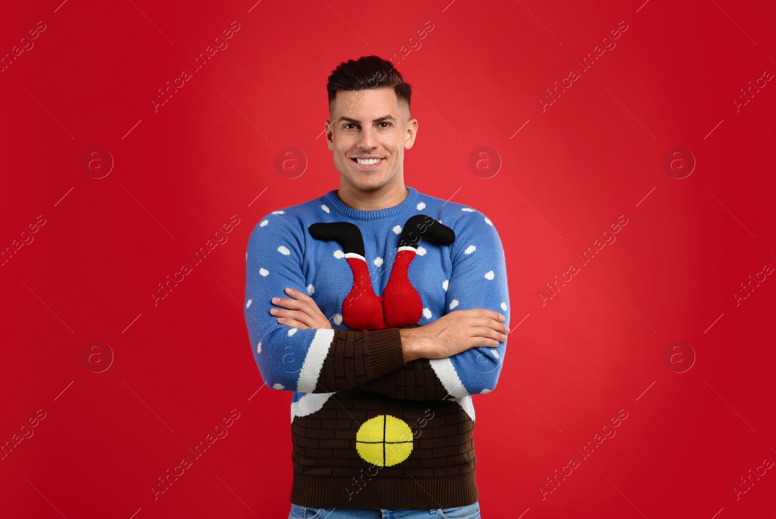 Photo of Happy man in Christmas sweater on red background