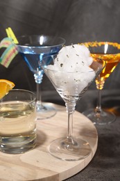 Tasty cotton candy cocktail and other alcoholic drinks in glasses on gray textured table