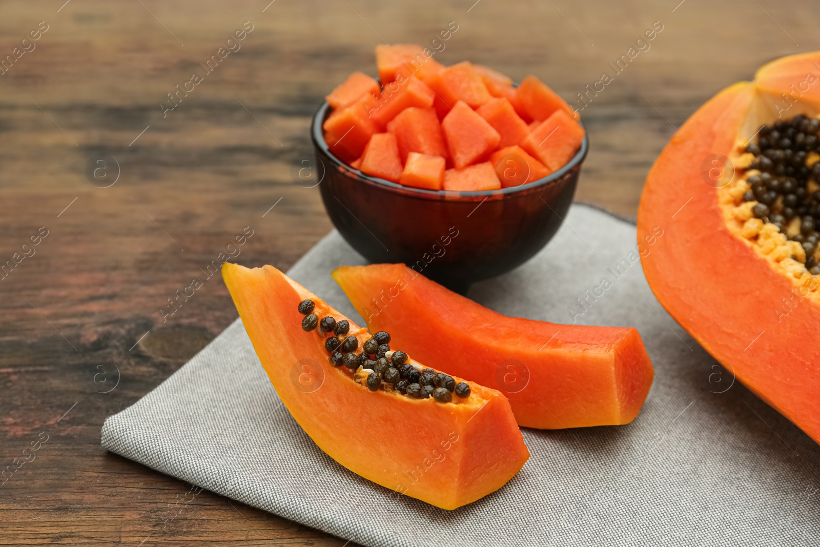 Photo of Tasty cut papaya fruits on wooden table