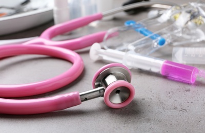 Stethoscope and other medical objects on grey table