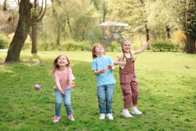 Easter celebration. Cute little children hunting eggs outdoors