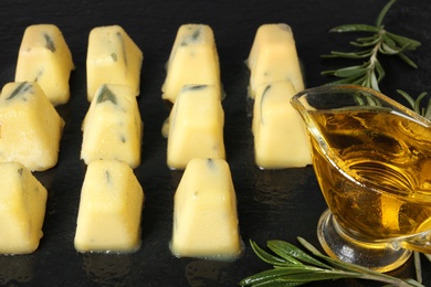 Photo of Rosemary and olive oil ice cubes on dark table