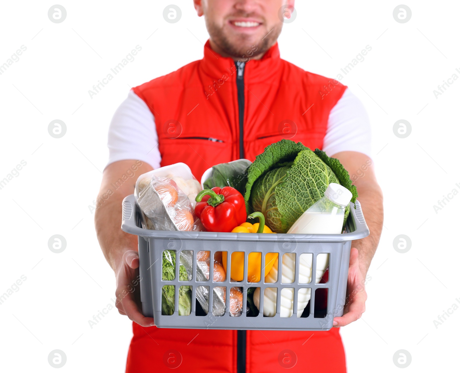 Photo of Delivery man holding plastic crate with food products on white background, closeup