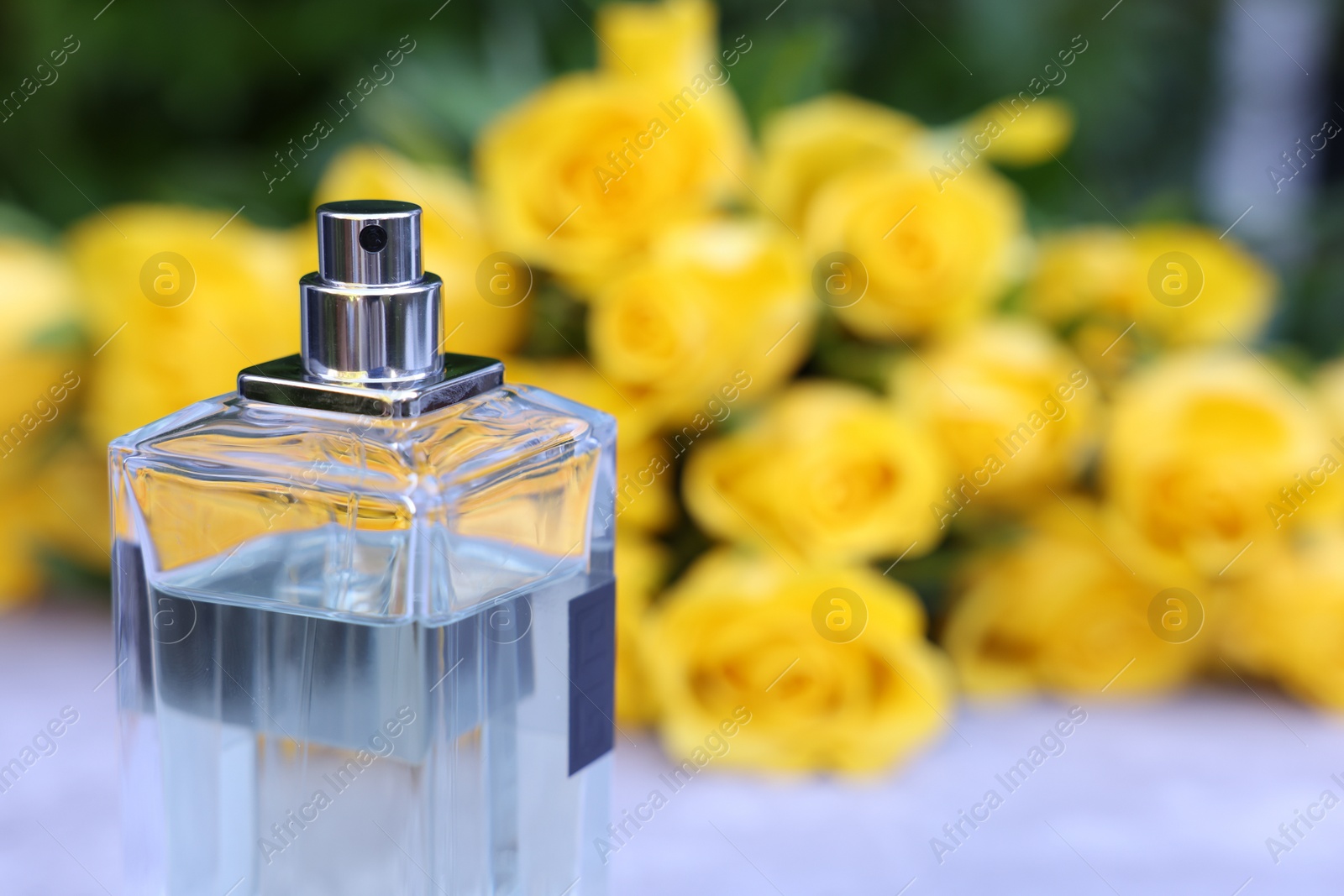 Photo of Perfume and beautiful bouquet of yellow roses, selective focus. Space for text