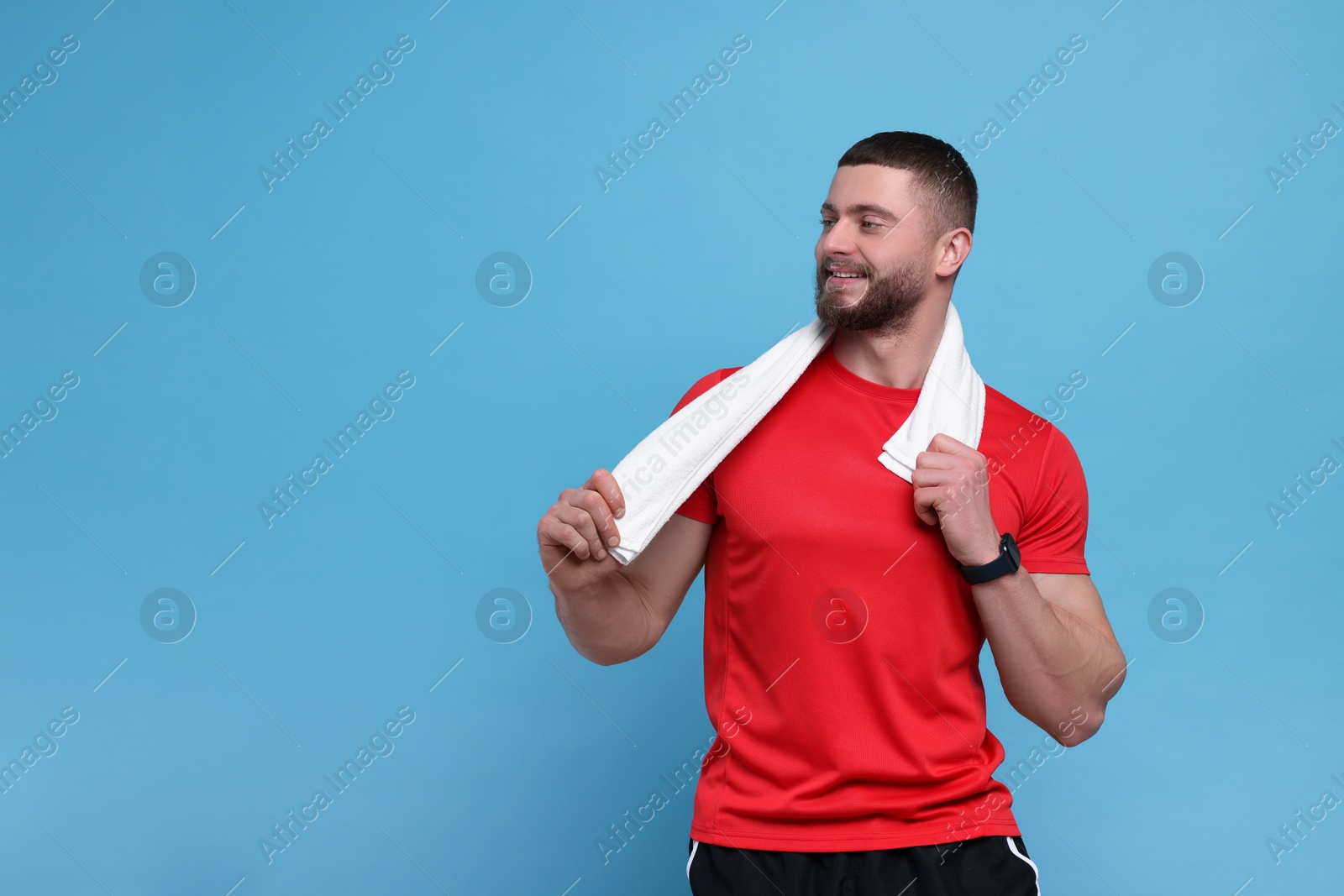 Photo of Handsome man with white towel on light blue background, space for text