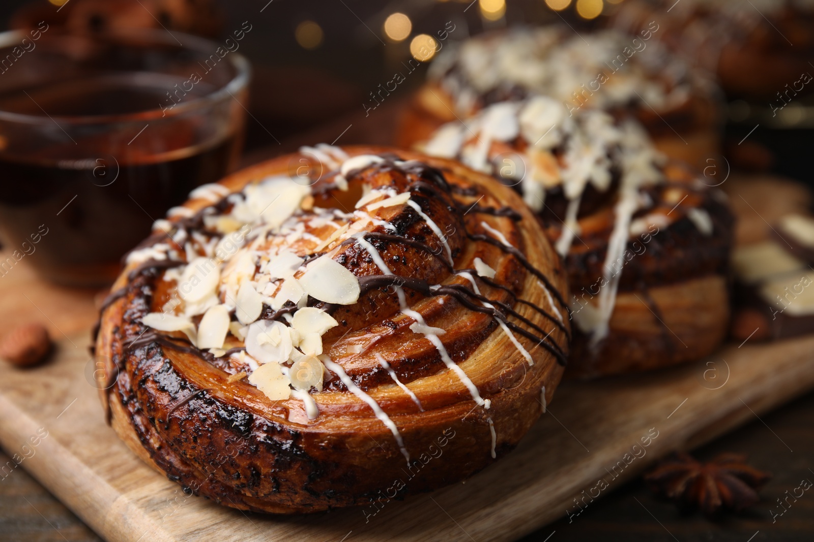 Photo of Delicious rolls with toppings and nuts on wooden table, closeup. Sweet buns