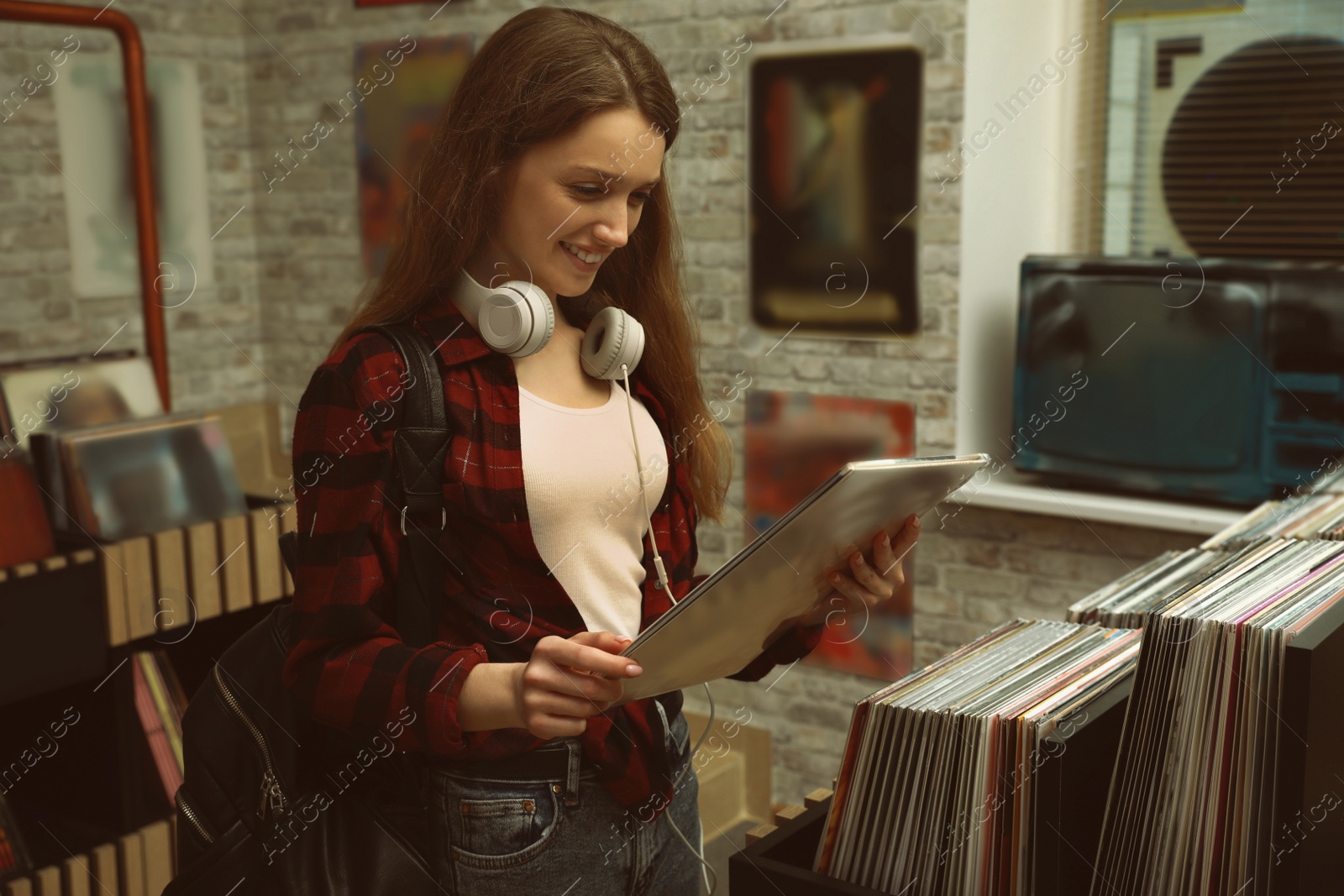 Image of Young woman with vinyl record in store