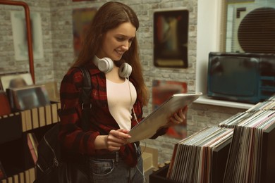 Image of Young woman with vinyl record in store