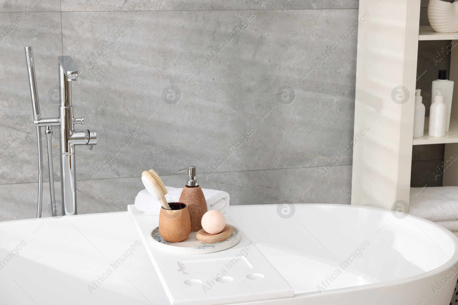 Photo of Different personal care products and accessories on bath tub in bathroom