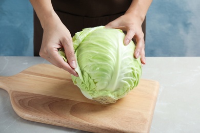 Photo of Woman with ripe cabbage at table, closeup