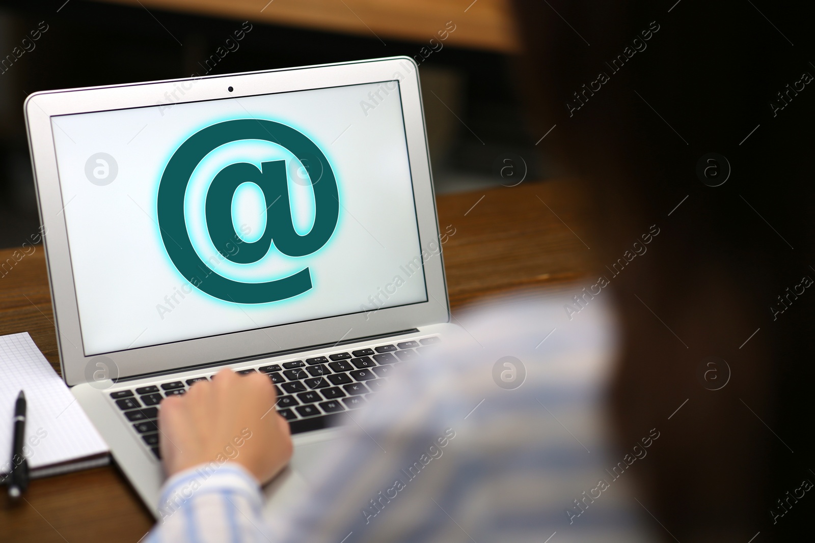 Image of Woman sending email via laptop at table, closeup