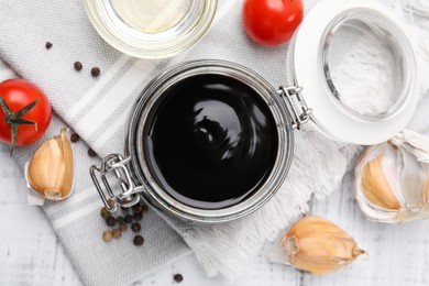 Organic balsamic vinegar and cooking ingredients on white table, flat lay