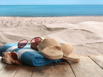 Beach accessories on wooden surface near sea 