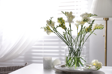 Beautiful spring freesia flowers on table in room