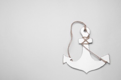 White wooden anchor figure on light background, top view. Space for text