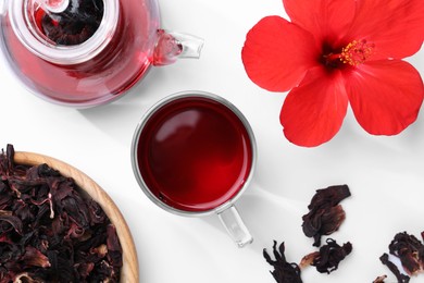 Delicious hibiscus tea and flowers on white background, flat lay