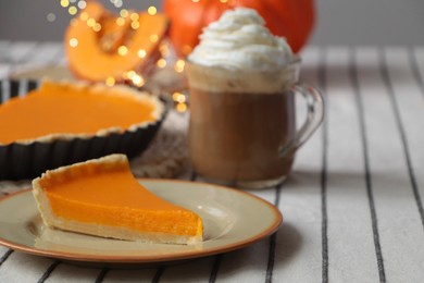 Photo of Fresh homemade pumpkin pie and cup of cocoa with whipped cream on table