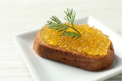 Slice of bread with pike caviar on white wooden table, closeup