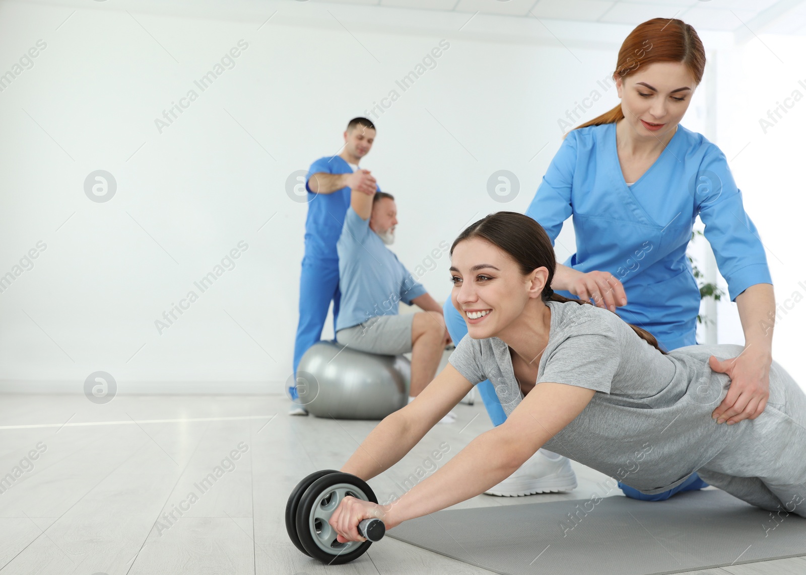 Photo of Professional physiotherapist working with female patient in rehabilitation center. Space for text