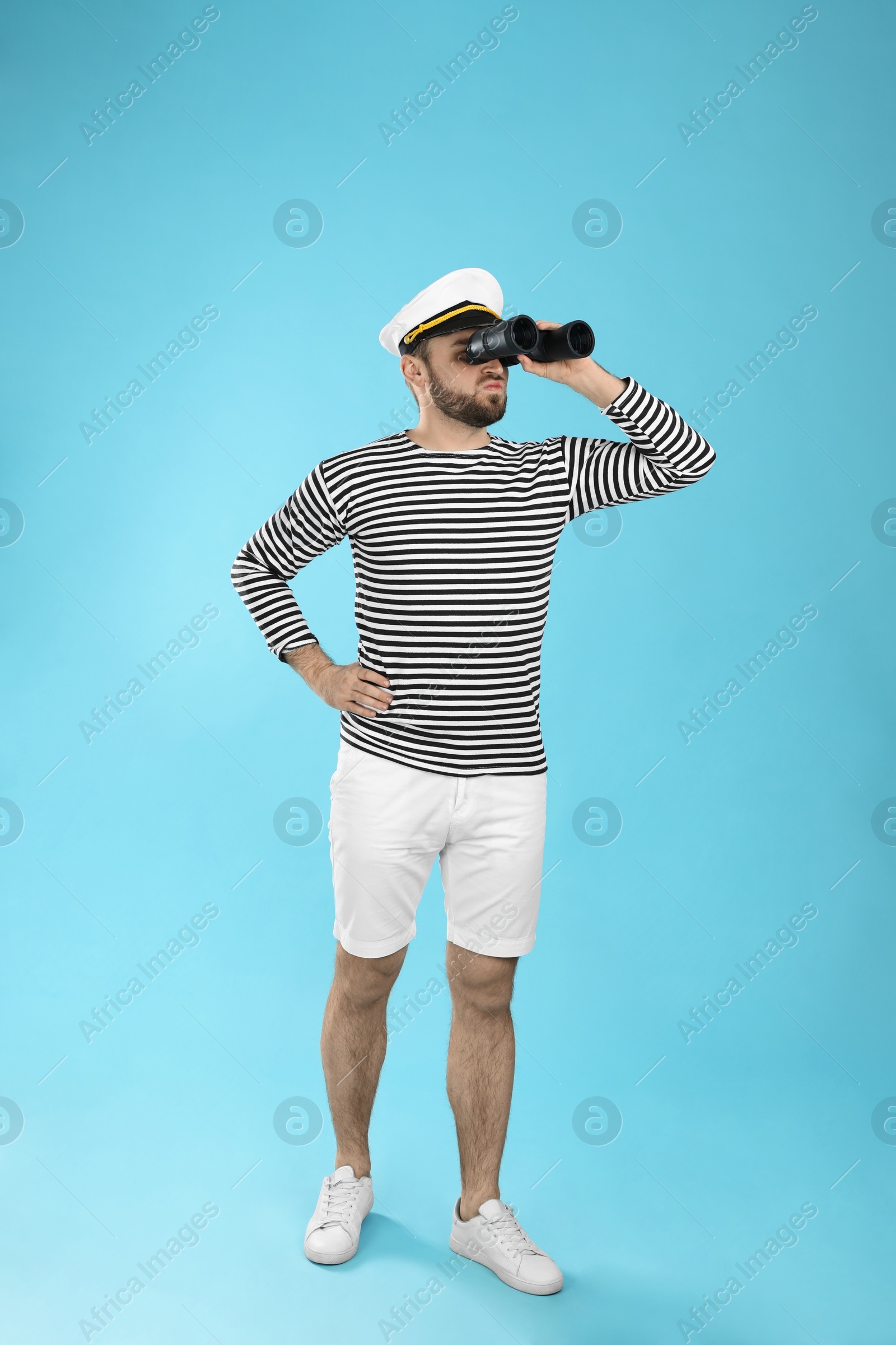 Photo of Sailor with binoculars on light blue background