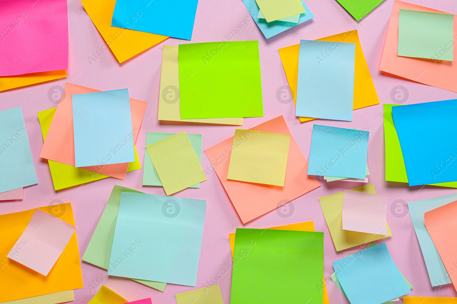 Photo of Blank colorful sticky notes on pink background, flat lay