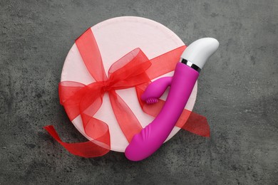 Photo of Gift box and pink vaginal vibrator on grey table, top view. Sex toy