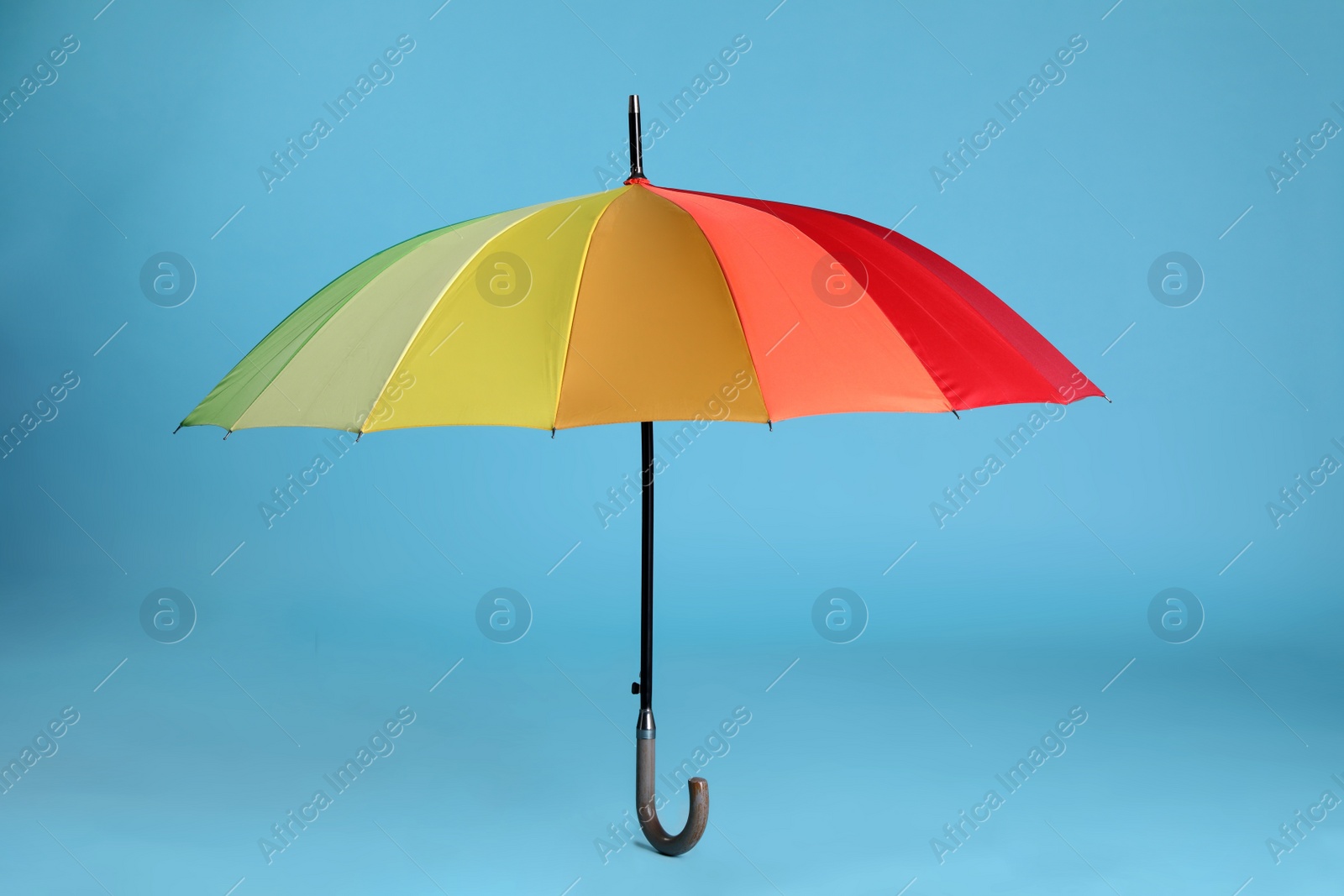 Photo of Stylish open bright umbrella on light blue background