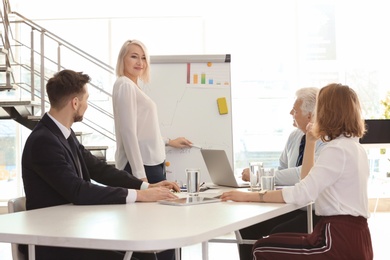 Photo of Group of people discussing ideas at table in office. Consulting service concept