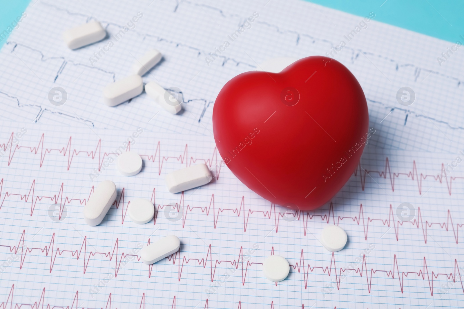 Photo of Red heart and pills on cardiogram. Cardiology concept