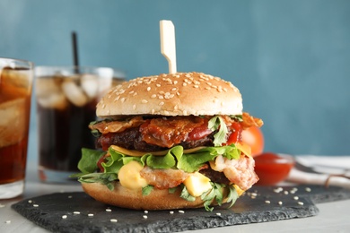 Tasty burger with bacon served on table