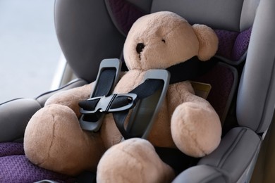 Photo of Teddy bear in child safety seat inside car