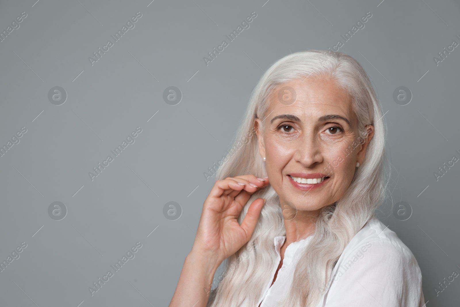 Photo of Portrait of beautiful mature woman on grey background, space for text