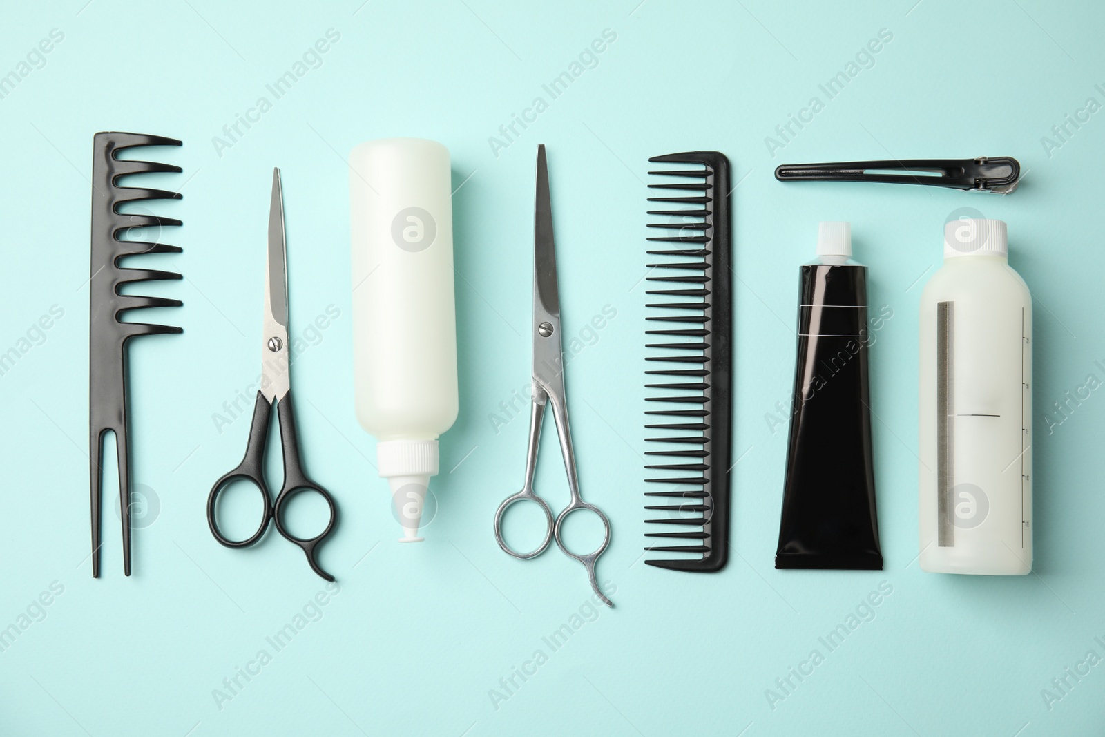 Photo of Professional tools for hair dyeing on light blue background, flat lay