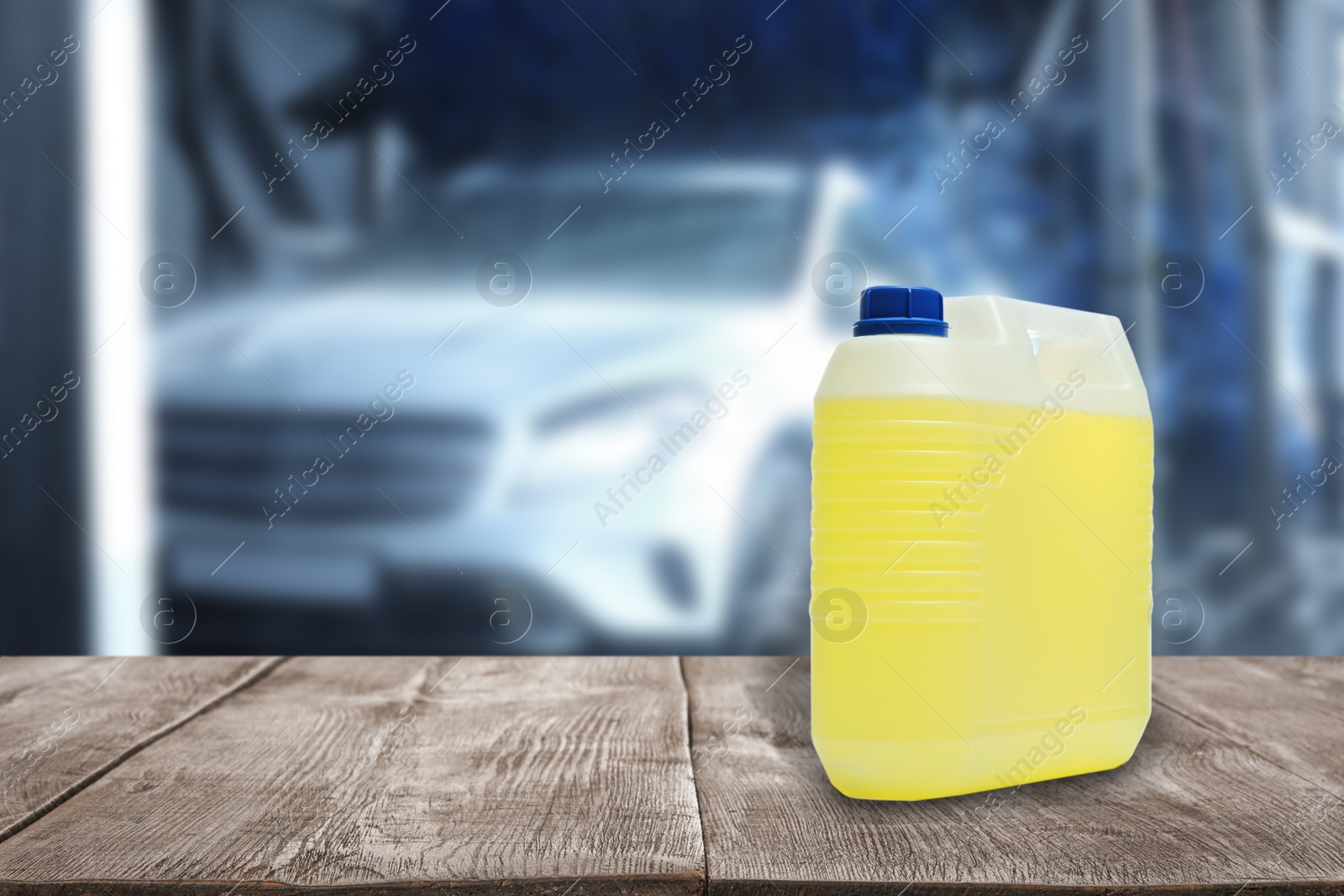 Image of Plastic canister with cleaning liquid for vehicle on wooden surface at car wash. Space for text