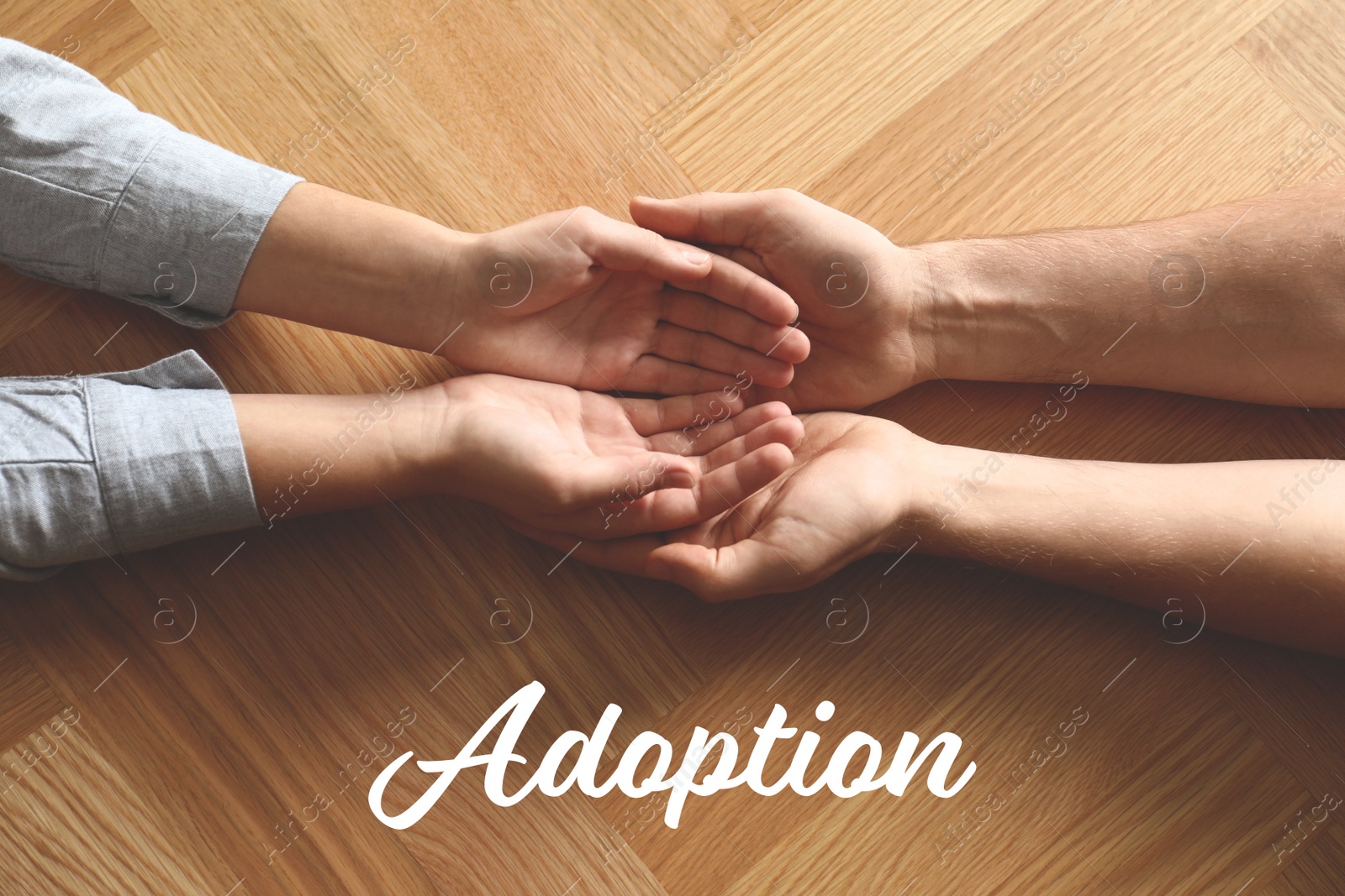 Image of People holding hands on wooden background, top view. Child adoption concept