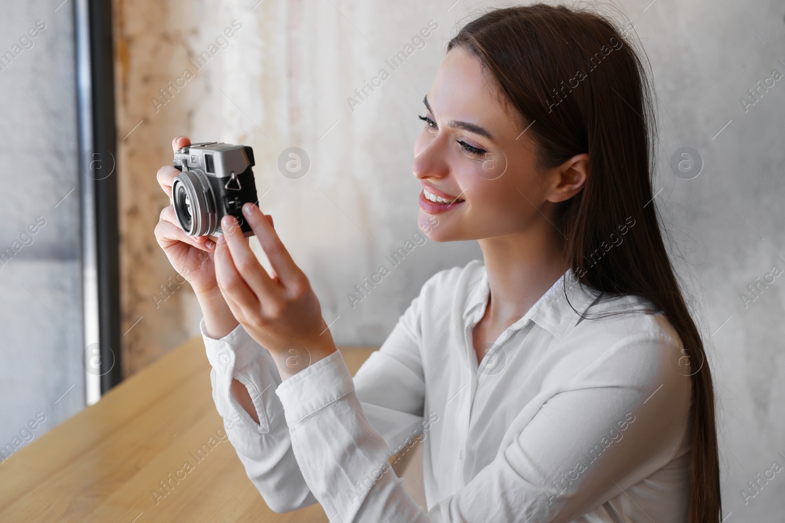 Photo of Young woman taking picture at cafe. Creative hobby