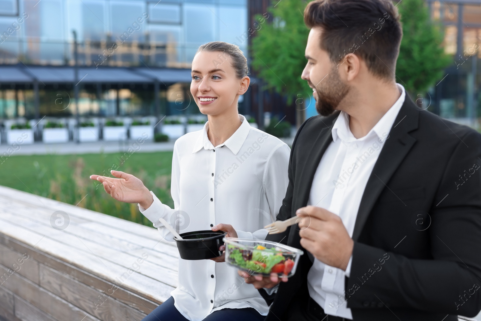 Photo of Smiling business woman talking with her colleague during lunch outdoors