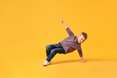 Happy little boy dancing on yellow background