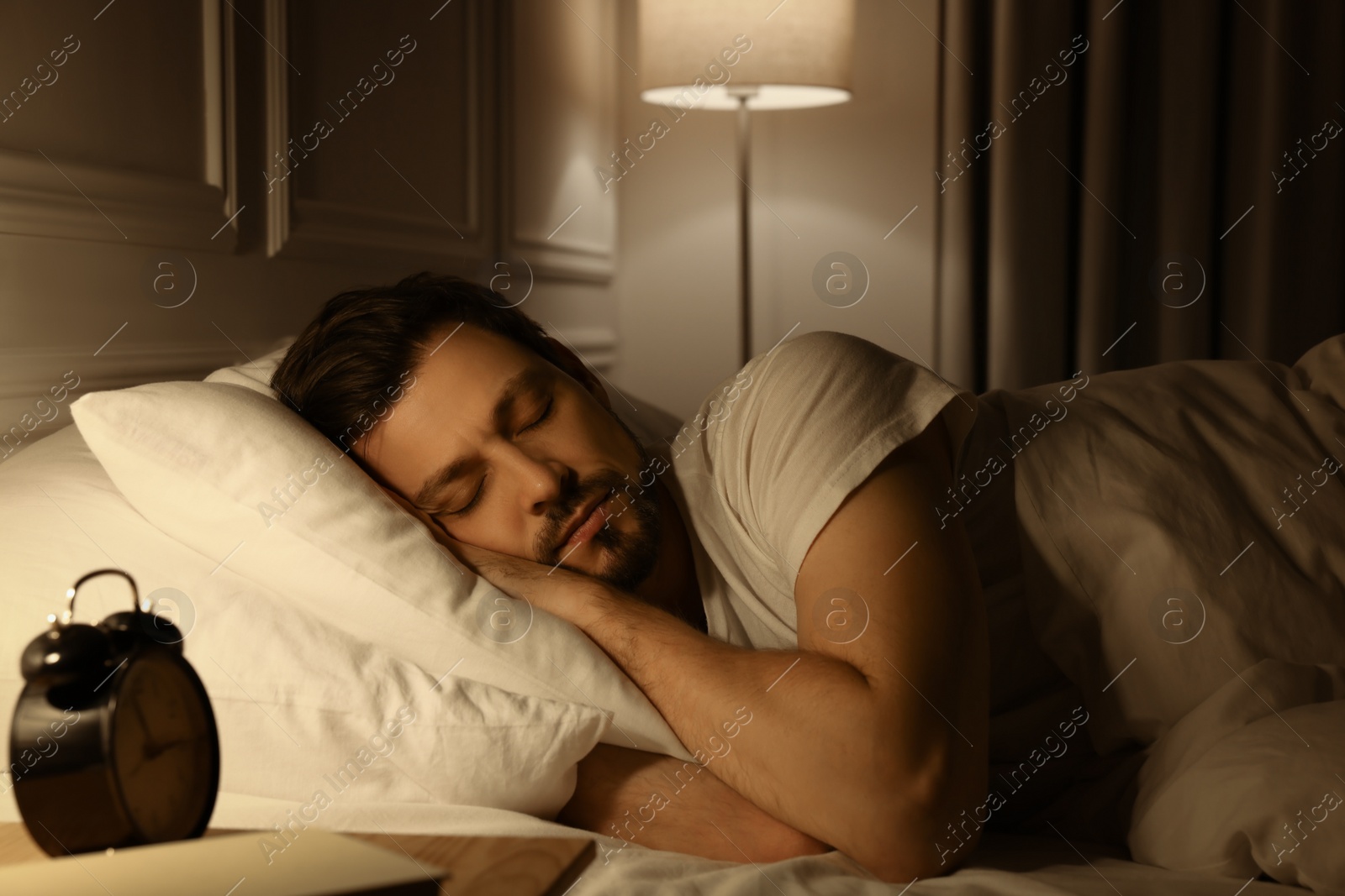 Photo of Handsome man sleeping in bed at night