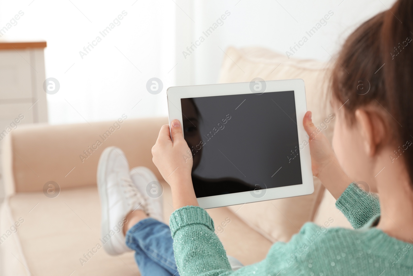 Photo of Little girl using video chat on tablet at home. Space for text