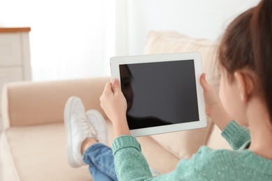Photo of Little girl using video chat on tablet at home. Space for text